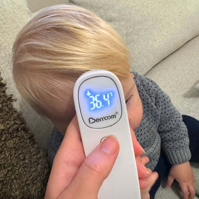 Pandetermometer måler temperaturen på et barns pande