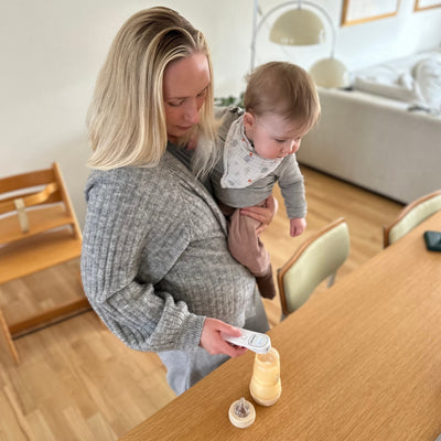 Pandetermometer måler temperaturen på en babyflaske